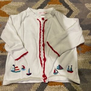 White cardigan with red trim and sailboats